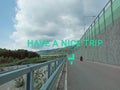 An endless road across a wonderful green landscape in Appennino Italy with the written have a nice trip