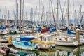 Endless rows of boats with little blue dinghy on pier at South Beach Harbor