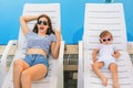 Endless summer. Cute baby and mother relaxing at sunbed Royalty Free Stock Photo