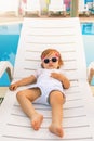 Cute baby relaxing at sunbed near pool at hawaii, hotel