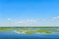 Endless summer landscape. Lake, forest and clear blue sky with beautiful little clouds. Royalty Free Stock Photo