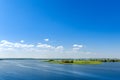 Endless summer landscape. Lake, forest and clear blue sky with beautiful little clouds. Royalty Free Stock Photo