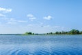 Endless summer landscape. Lake, forest and clear blue sky with beautiful little clouds. Royalty Free Stock Photo