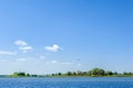 Endless summer landscape. Lake, forest and clear blue sky with beautiful little clouds. Royalty Free Stock Photo