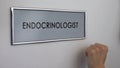 Endocrinologist office door, patient hand knocking closeup, thyroid disease