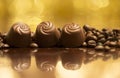 Chocolates and coffee beans on golden background