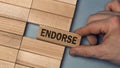 ENDORSE word concept. Close-up wooden piece blocks on the table