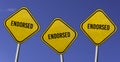 Endorsed - three yellow signs with blue sky background