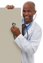 Endorsing your healthcare message. A young doctor holding a stethoscope up to a board reserved for copyspace.