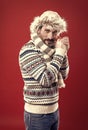 Enduring cold. A winter ensemble protects him from cold. Bearded man accessorizing sweater with hat and scarf. Mature Royalty Free Stock Photo