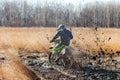 Enduro bike rider in a field with dry grass in autumn