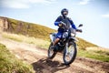 Enduro biker crossing road at high speed in Carpathian mountains