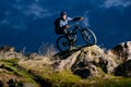 Enduro Cyclist Riding the Bike on the Rock at Night. Extreme Sport Concept. Space for Text. Royalty Free Stock Photo