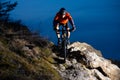 Enduro Cyclist Riding the Bike on the Rock at Night. Extreme Sport Concept. Space for Text. Royalty Free Stock Photo