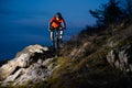 Enduro Cyclist Riding the Bike on the Rock at Night. Extreme Sport Concept. Space for Text. Royalty Free Stock Photo