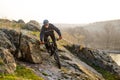 Enduro Cyclist Riding the Mountain Bike Down Beautiful Rocky Trail. Extreme Sport Concept. Space for Text.