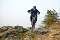 Enduro Cyclist Riding the Mountain Bike Down Beautiful Rocky Trail. Extreme Sport Concept. Space for Text.