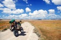 Enduro motorcycle traveler with suitcases standing on a dirt road