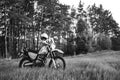 Enduro off road Motorcycle on green grass hill landscape pine forest sunset