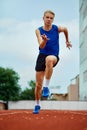 Energetic athlete dashing with determination. Full length portrait of professional sportsman fast running on sport field Royalty Free Stock Photo