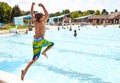 Energetic boy jumping in outdoor swimming pool Royalty Free Stock Photo