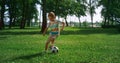 Energetic boy warming up before football match. Focused child play on field.