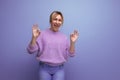 energetic cute blond woman in lavender sweater on purple background with copy space