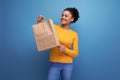 energetic cute young 25 year old hispanic lady holding out a craft shopping bag Royalty Free Stock Photo