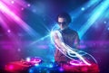 Energetic Dj mixing music with powerful light effects