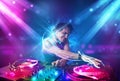 Energetic Dj mixing music with powerful light effects