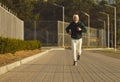 Energetic Elderly Runner in City Park at Autumn Sunset