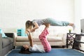 Female Lifting Best Friend With Her Feet In Living Room