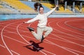 Energetic girl child jump at athletics track physical education outdoors, sport
