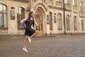 Energetic happy kid hurry to school in uniform with book carrying backpack outdoors, back to school, copy space