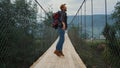 Energetic man backpacking mountains on nature hike. Tourist jump on river bridge Royalty Free Stock Photo
