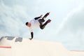 Energetic man on roller skates in motion at modern roller skate park. Roller skater doing dangerous and daring tricks