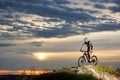 Energetic man in sportswear cycling on rock hill. Royalty Free Stock Photo