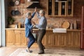 Energetic middle aged family couple dancing in kitchen. Royalty Free Stock Photo