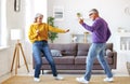 Energetic senior family couple dancing together in living room at home, moving to music Royalty Free Stock Photo