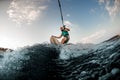 man holds rope and catches a wave on wakesurf. Wakesurfing on the river.