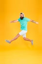 Energetic and upbeat music for leisure. Energetic hipster jumping high on yellow background. Bearded man in mid air