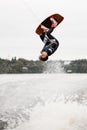 energetic young woman masterfully jumping and flipping over the water on wakeboard Royalty Free Stock Photo