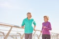 Energize your life. Active mature family couple in sportswear smiling at each other while running together on a sunny