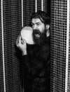 Energized handsome man, bearded hipster with beard and moustache in red checkered shirt pours bucket of ice water on