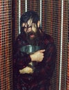 Energized handsome man, bearded hipster with beard and moustache in red checkered shirt wet with water in shower with