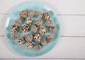 Energy balls of dried fruits and nuts sprinkled with sesame and granola lie on a blue porcelain plate on a white wooden table. Royalty Free Stock Photo