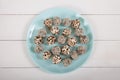 Energy balls of dried fruits and nuts sprinkled with sesame and granola lie on a blue porcelain plate on a white wooden table. Top Royalty Free Stock Photo