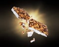 Energy cereal bars broken into two halves with a flash of light in the dark Royalty Free Stock Photo