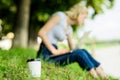 Energy charge and refreshment. Coffee cup take away close up shot. Coffee cup on green grass woman worker with laptop Royalty Free Stock Photo