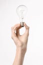 Energy consumption and energy saving topic: human hand holding a light bulb on a white background in studio